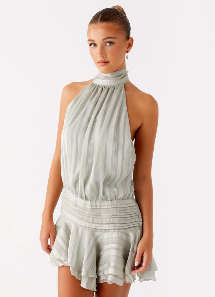 Elegant Harrow Aldora pleated mini dress with halter neckline, perfect for cocktail parties, shown on a woman.