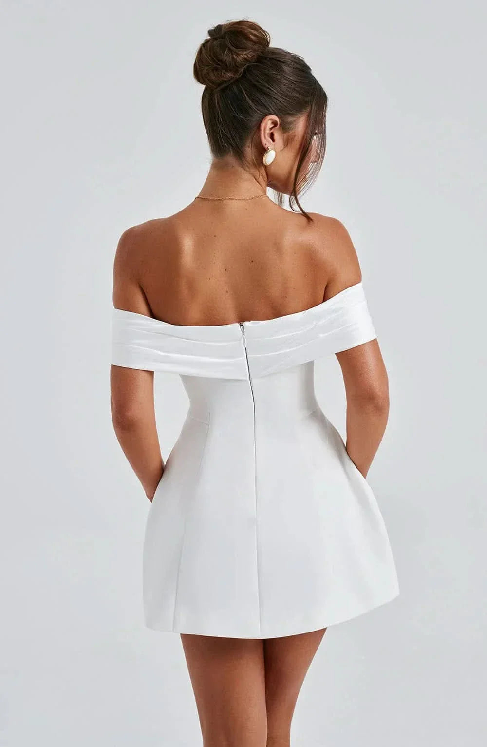 Women wearing Harrow amber off-shoulder mini dress with bow detail, perfect for romantic cocktail parties.