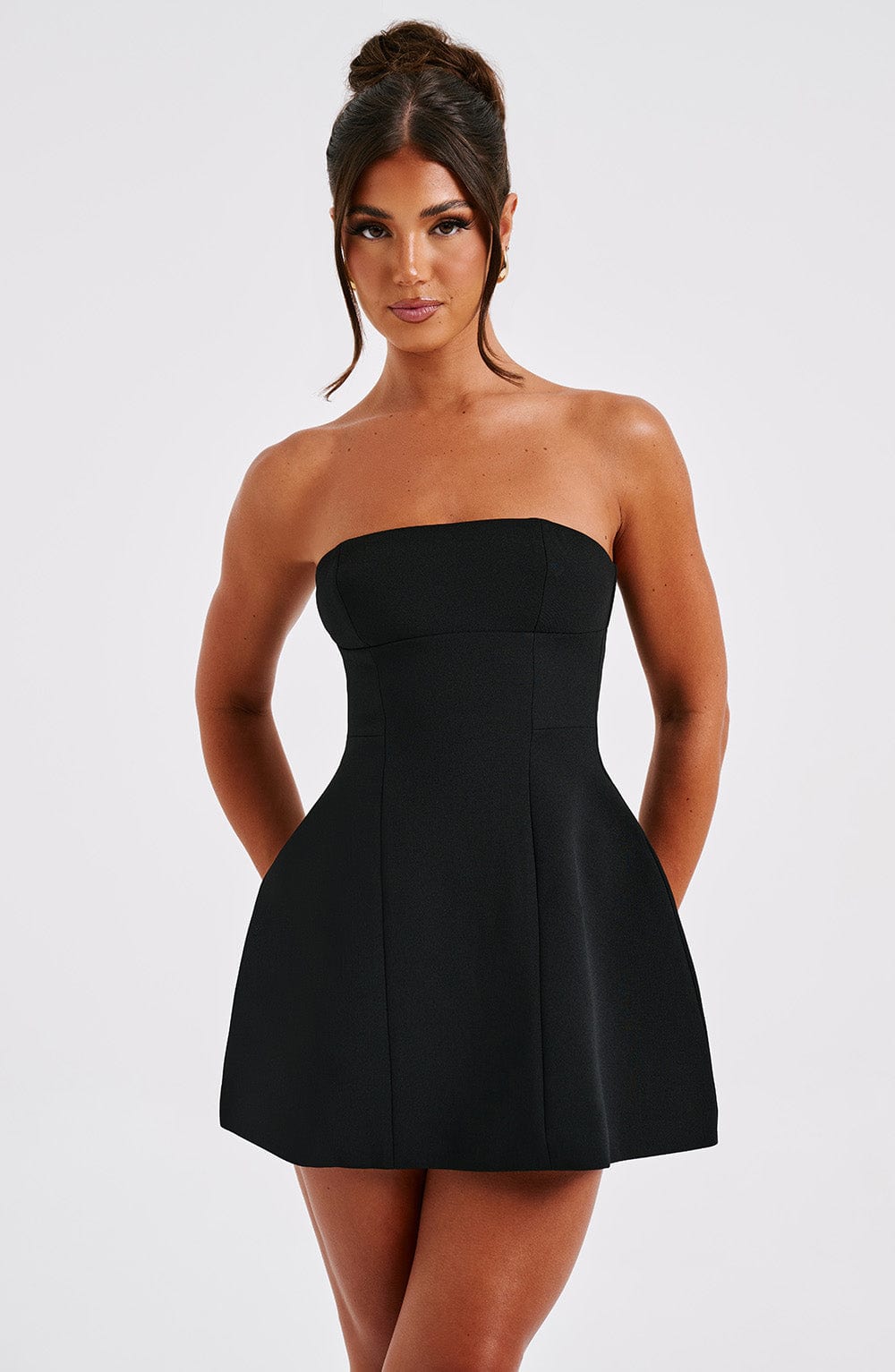 Women wearing the Athena playful ruffle mini dress by Harrow, strapless cocktail dress with bubble skirt detail.