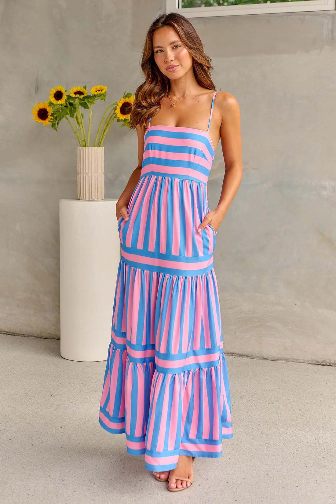 Women wearing the Harrow Cybele striped maxi dress with pockets, featuring a straight neckline and a flowy summer design.