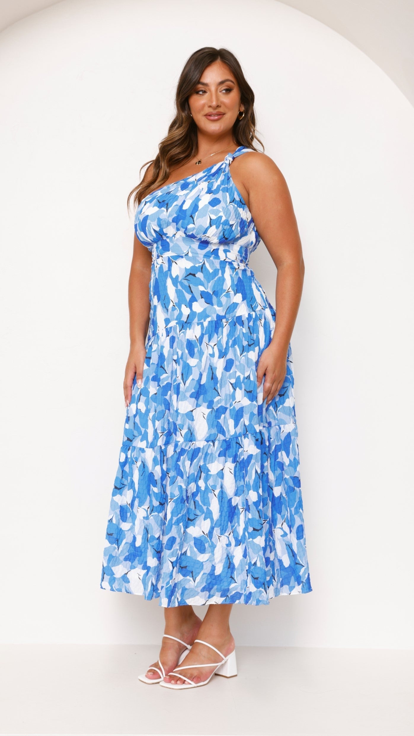 Women wearing the Harrow Elodie floral maxi dress with a one-shoulder design, perfect for wedding guests.