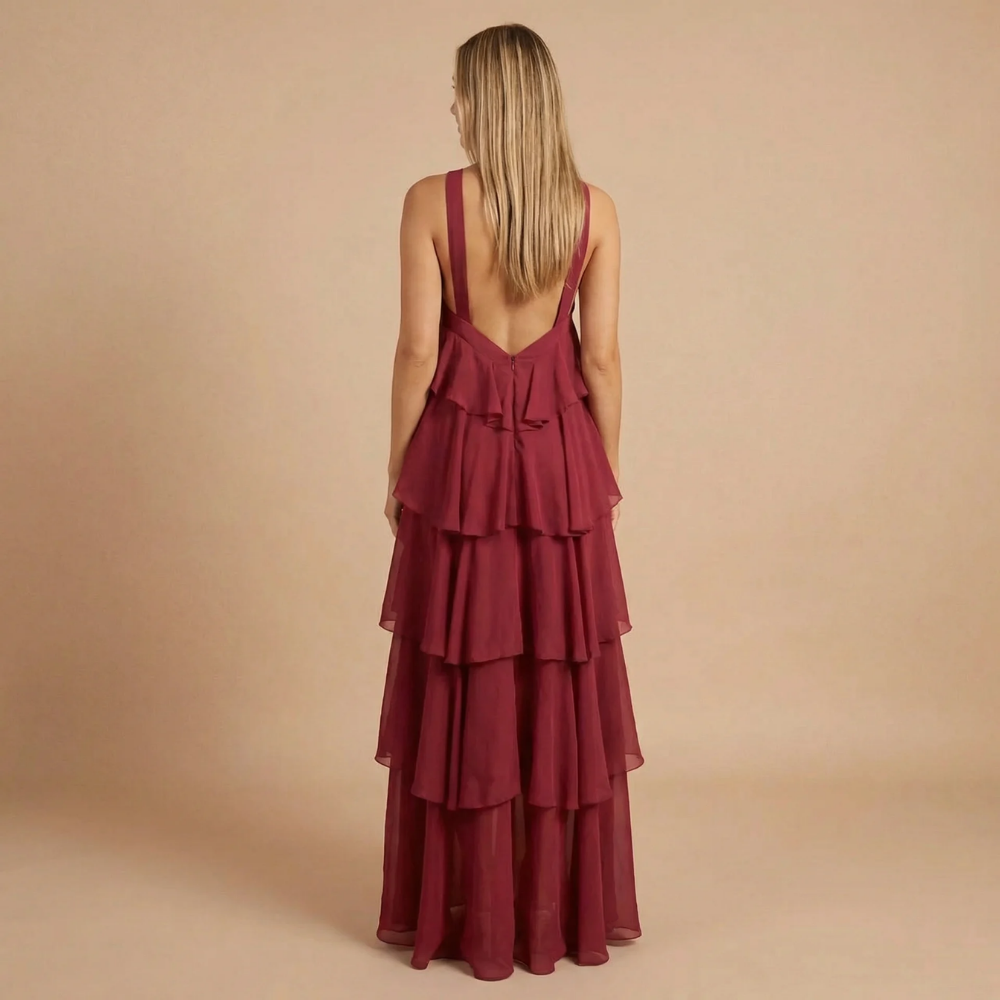 Women wearing a Fleur playful ruffle maxi dress by Harrow, featuring a halter neckline and tiered design for wedding guest attire.