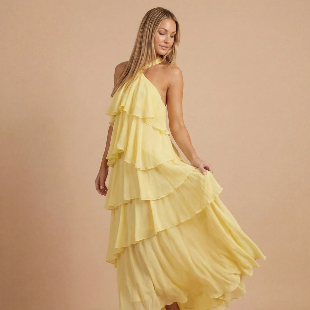 Women wearing the Fleur playful ruffle maxi dress by Harrow, halter neck, tiered design, perfect for wedding guests.