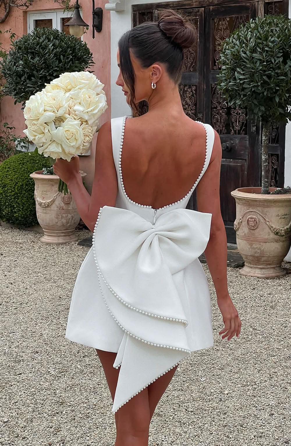 Harrow Giovanna elegant sleeveless mini dress with pearl trim, perfect for wedding guests, displayed on a model.