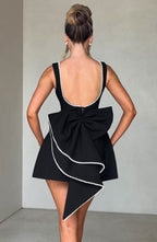 Elegant women's sleeveless mini dress by Harrow with pearl trim, perfect for wedding guests, shown on a model.