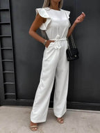 Women wearing the Harriet Harrow ruffle sleeve wide-leg jumpsuit, perfect for wedding guests, featuring elegant flowing fabric and stylish design.