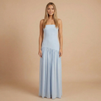 Elegant strapless maxi dress by Harrow featuring a slit, perfect for wedding guests, styled on a woman with flowing hair.