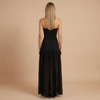 Elegant strapless maxi dress by Harrow featuring a slit, ideal for wedding guests, shown on a woman in a formal setting.