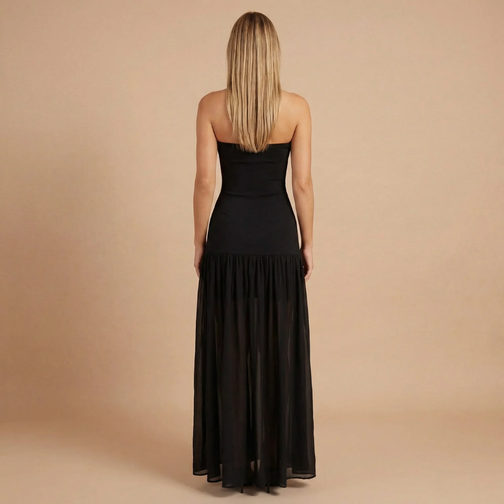 Elegant strapless maxi dress by Harrow featuring a slit, ideal for wedding guests, shown on a woman in a formal setting.