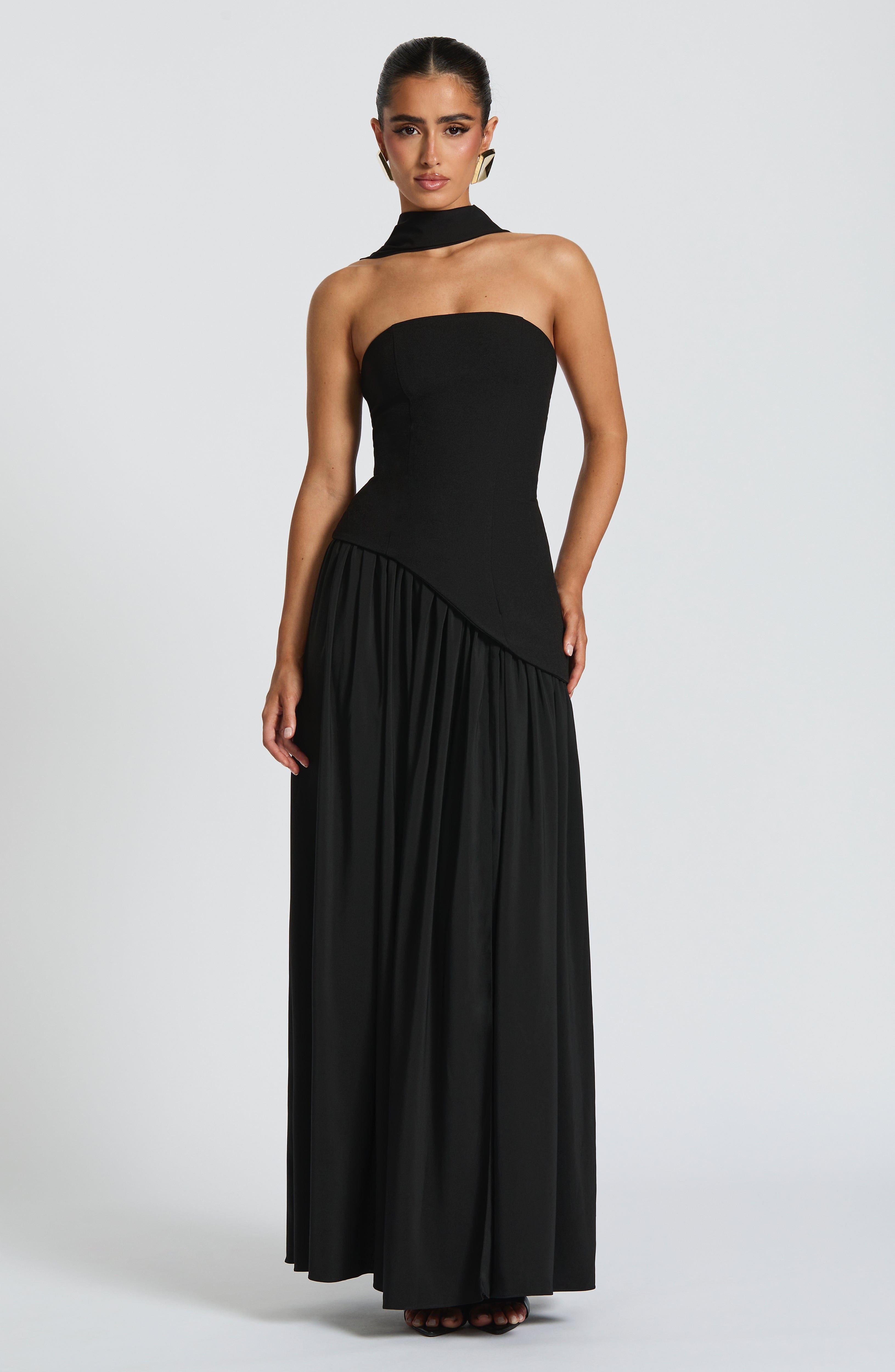 Elegant strapless maxi dress by Harrow featuring a slit, perfect for wedding guests, shown on a woman in a formal setting.