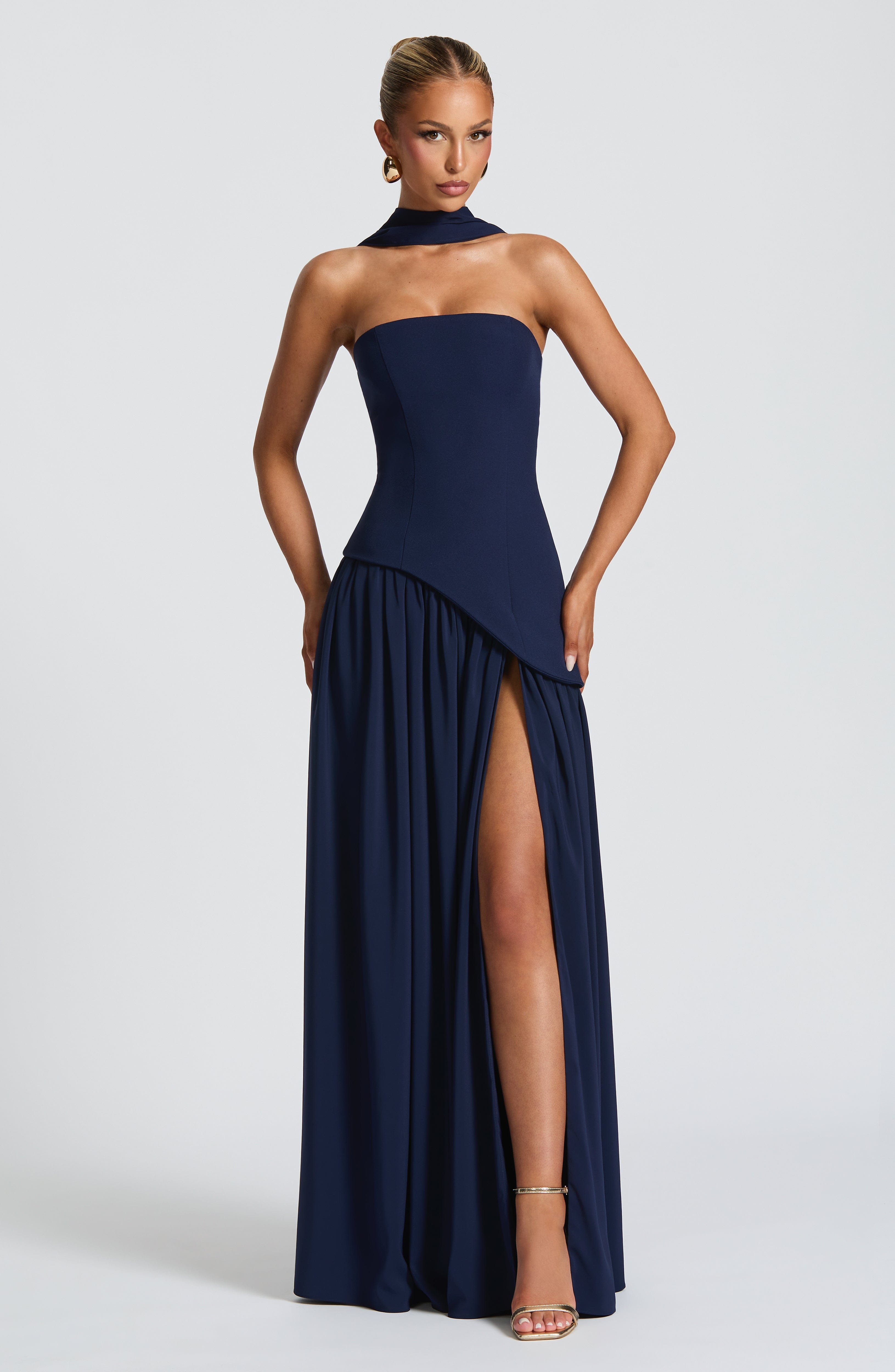 Elegant strapless maxi dress by Harrow for wedding guests, featuring a stylish slit and flowing fabric.
